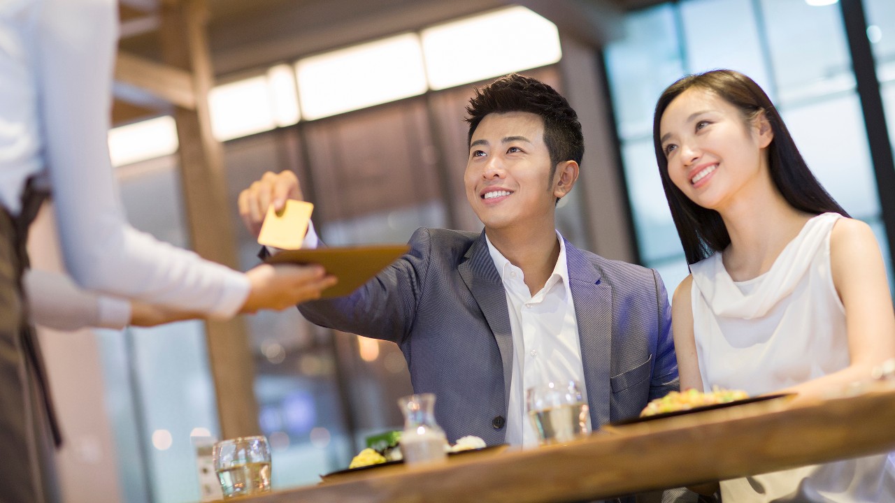 A couple paying for lunch with a credit card; image used for HSBC Vietnam common question page