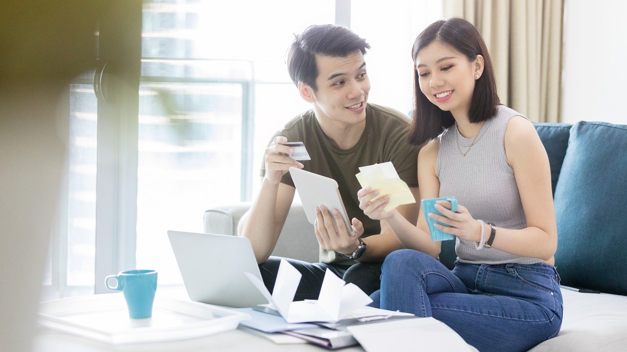 young couple discussing credit card debt on couch