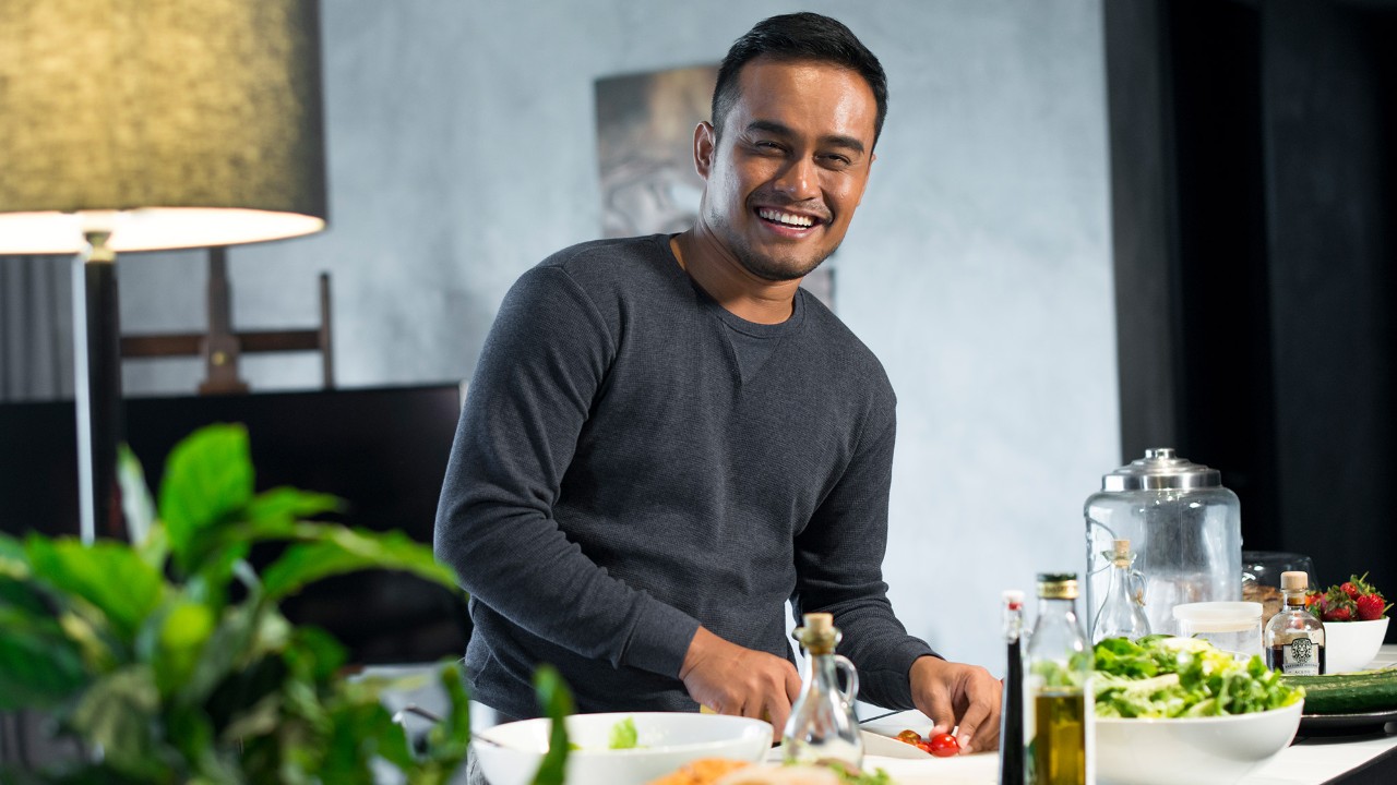 a man eating salad happily; image used for HSBC Vietnam personal instalment loan page.