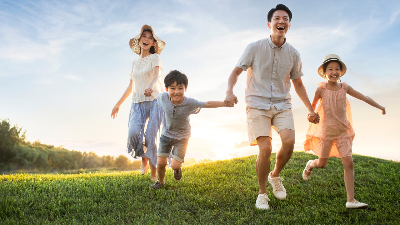 Parents and children happily holding hands outdoors; image used for HSBC Vietnam Accounts page