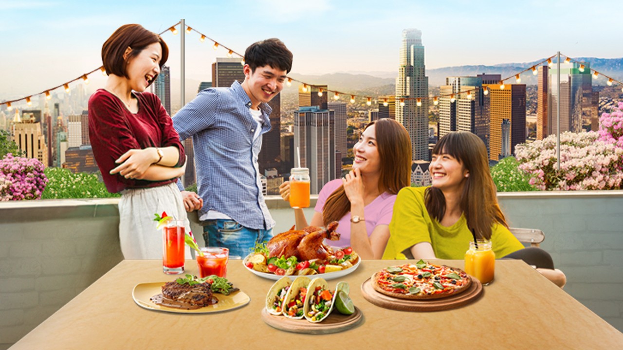 Four happy friends having dinner on a rooftop; image used for HSBC Vietnam Daily Offers page.