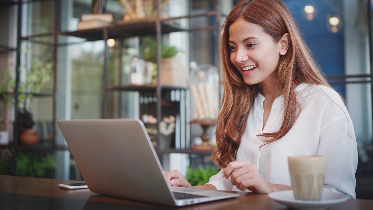 a woman using laptop in a coffee shop; image used for HSBC Vietnam Online Banking page