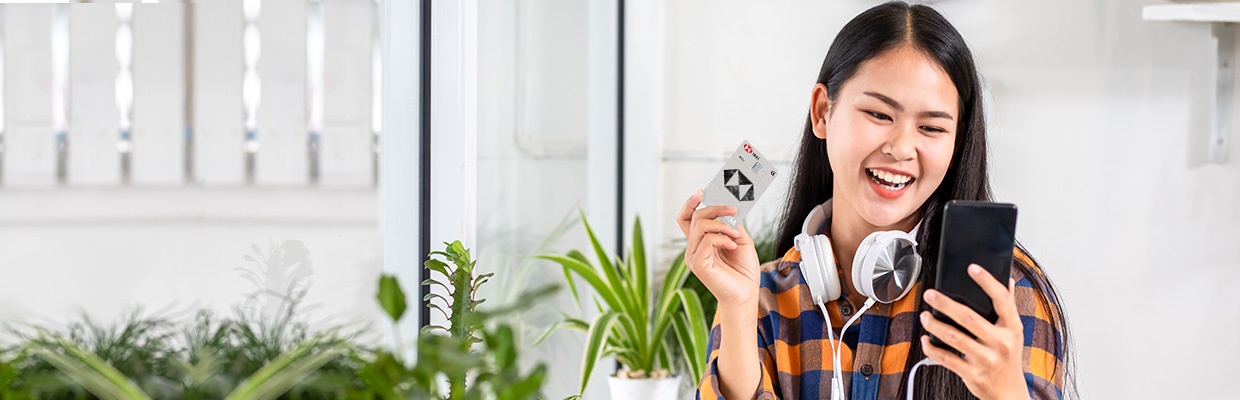 A woman is holding a credit card while talking on the phone; image used for HSBC VN How to get a 45-day interest-free period