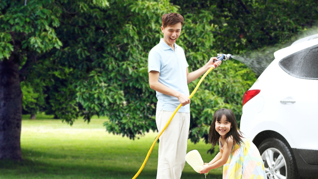  Father and daughter washing car at backyard; image used for HSBC Vietnam Car Insurance page