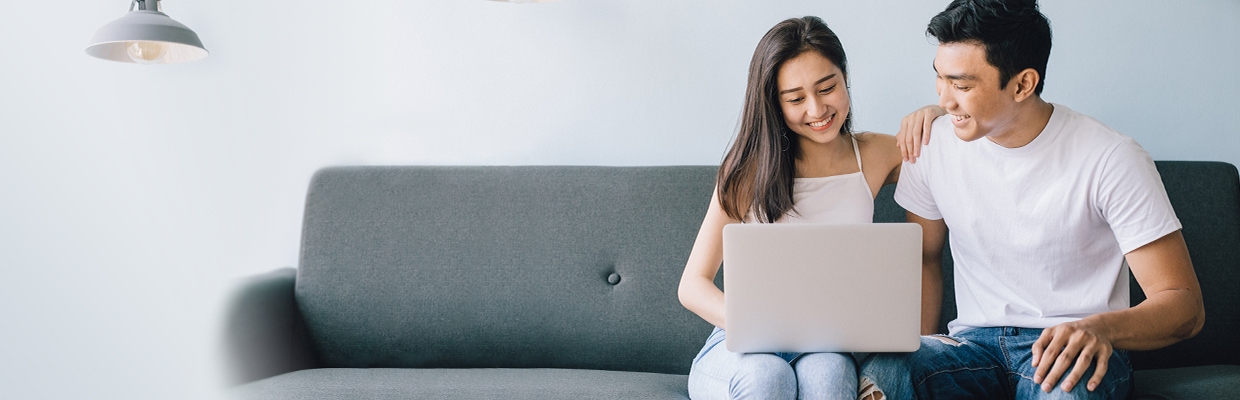 couple using laptop on couch; image used for HSBC Vietnam Loan Comparison page