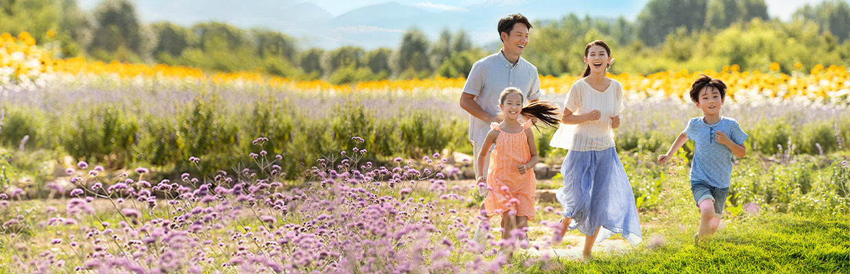 Happy young family in flower field; image used for HSBC Vietnam Life Insurance Offer page