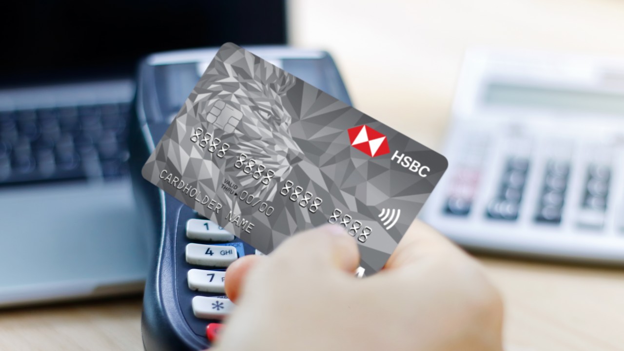 một chàng trai đang thanh toán bằng thẻ HSBC tại máy POS
