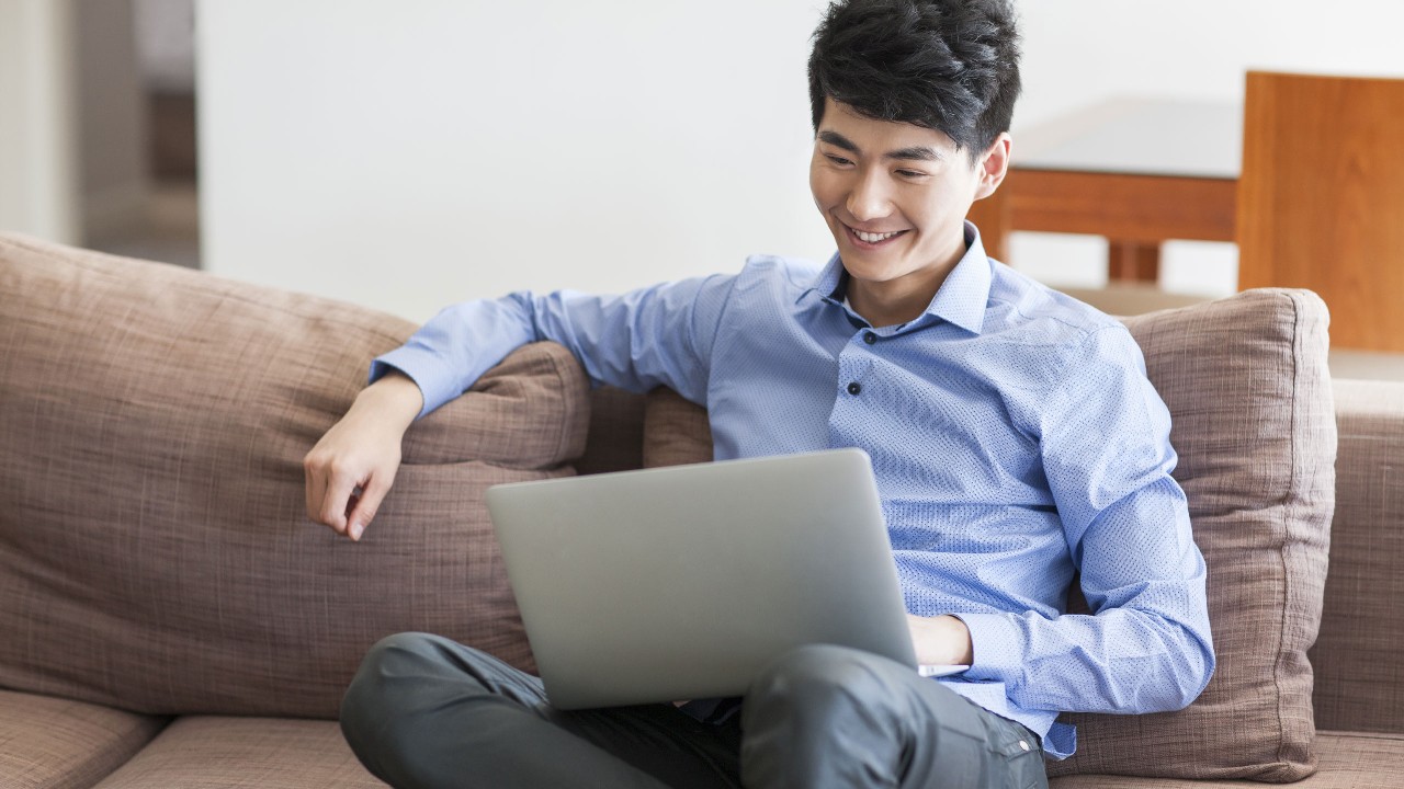 Happy young man using laptop