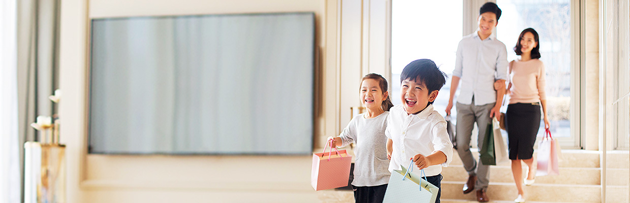 A family of four coming back home with shopping bags; image used for HSBC Vietnam Rewards catalogue page.