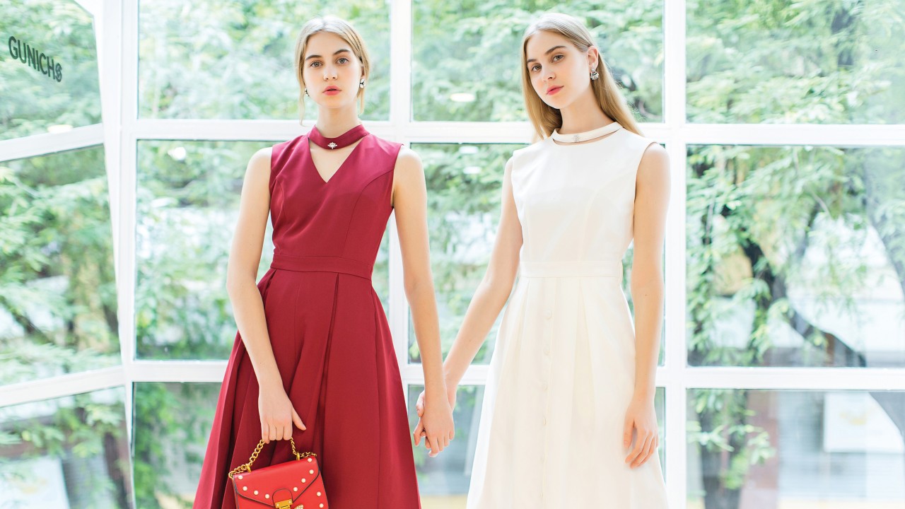 Two female models standing holding hands, one in red dress while another one in white dress; image used for HSBC Vietnam debit card privilege club page