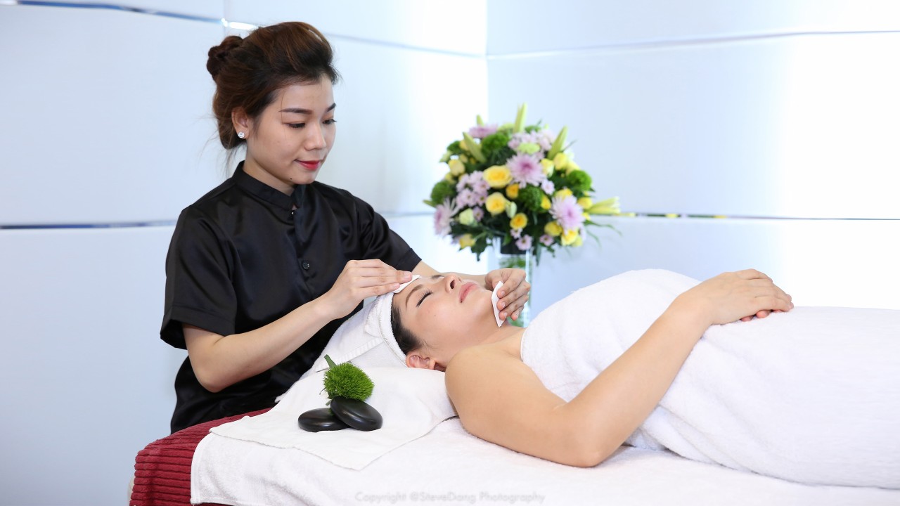 A woman is enjoying a facial treatment; image used for HSBC Vietnam debit card privilege club page