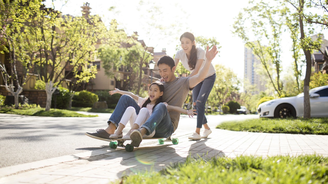 A father and his daughter sitting on a skateboard and the mother pushing them; image used for HSBC Vietnam Remittance fee waiver and preferential foreign exchange rates page