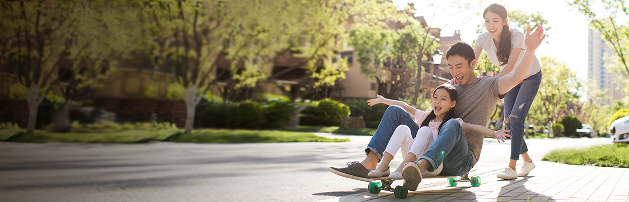 A father and his daughter sitting on a skateboard and the mother pushing them; image used for HSBC Vietnam Remittance fee waiver and preferential foreign exchange rates page