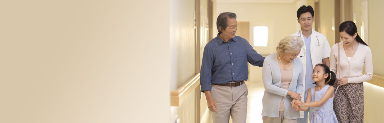 A family smiling and standing in the corridor; image used for HSBC Vietnam Medical Care Insurance page