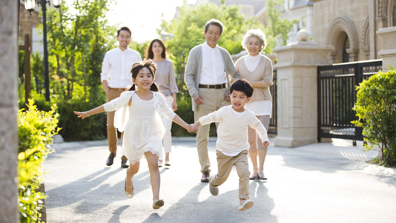 a girl and a boy running in front of their parents and grandparents; image used for HSBC Vietnam Healthier 100 page.