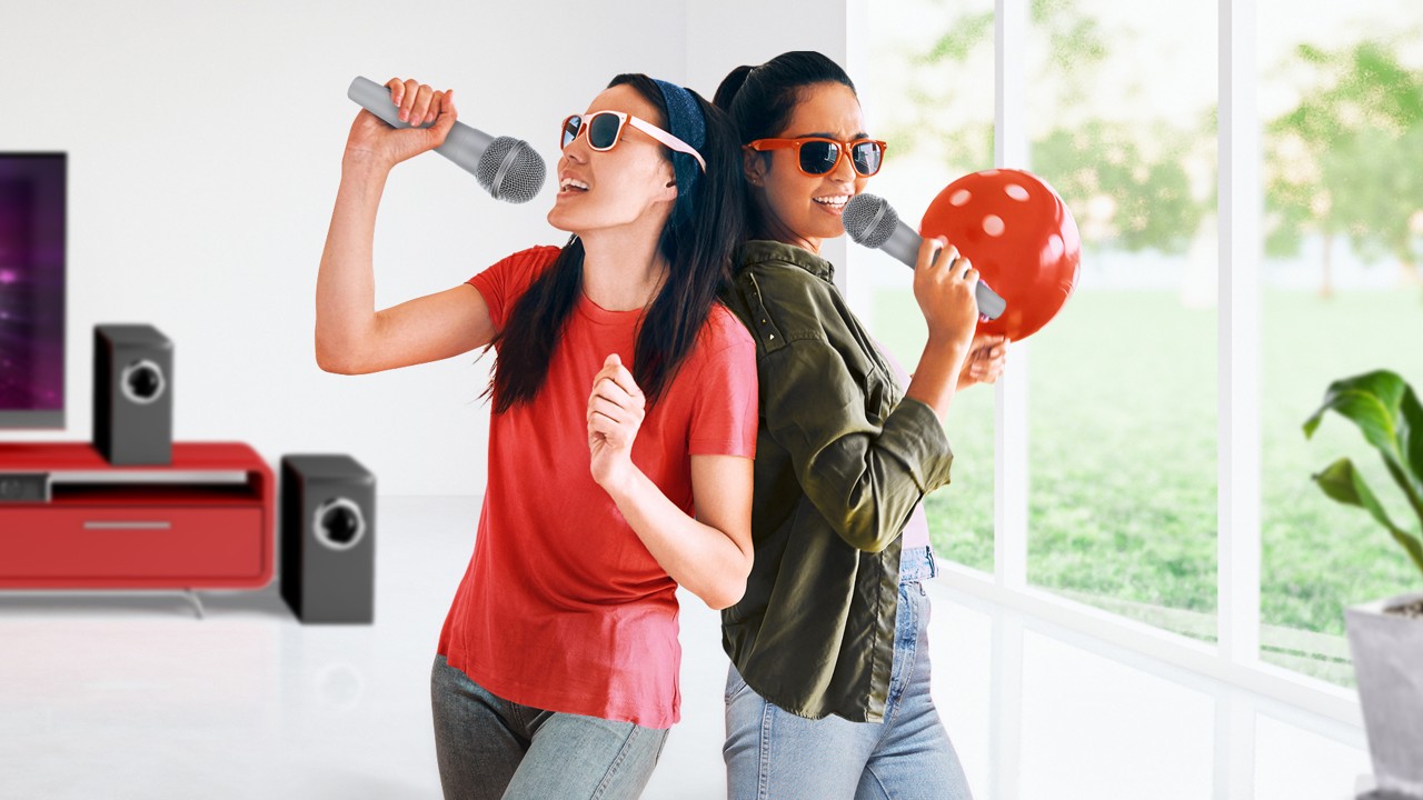 two women are singing karaoke at home; image used for HSBC VN Personal Instalment Loan page.