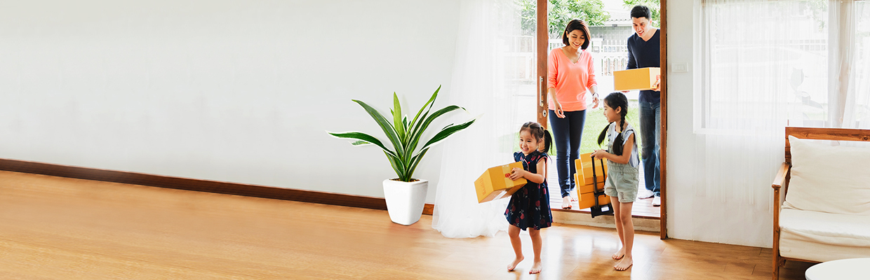 A family of four entering a house carrying some moving boxes; image used for HSBC Vietnam Home Mortgage Loan Page.