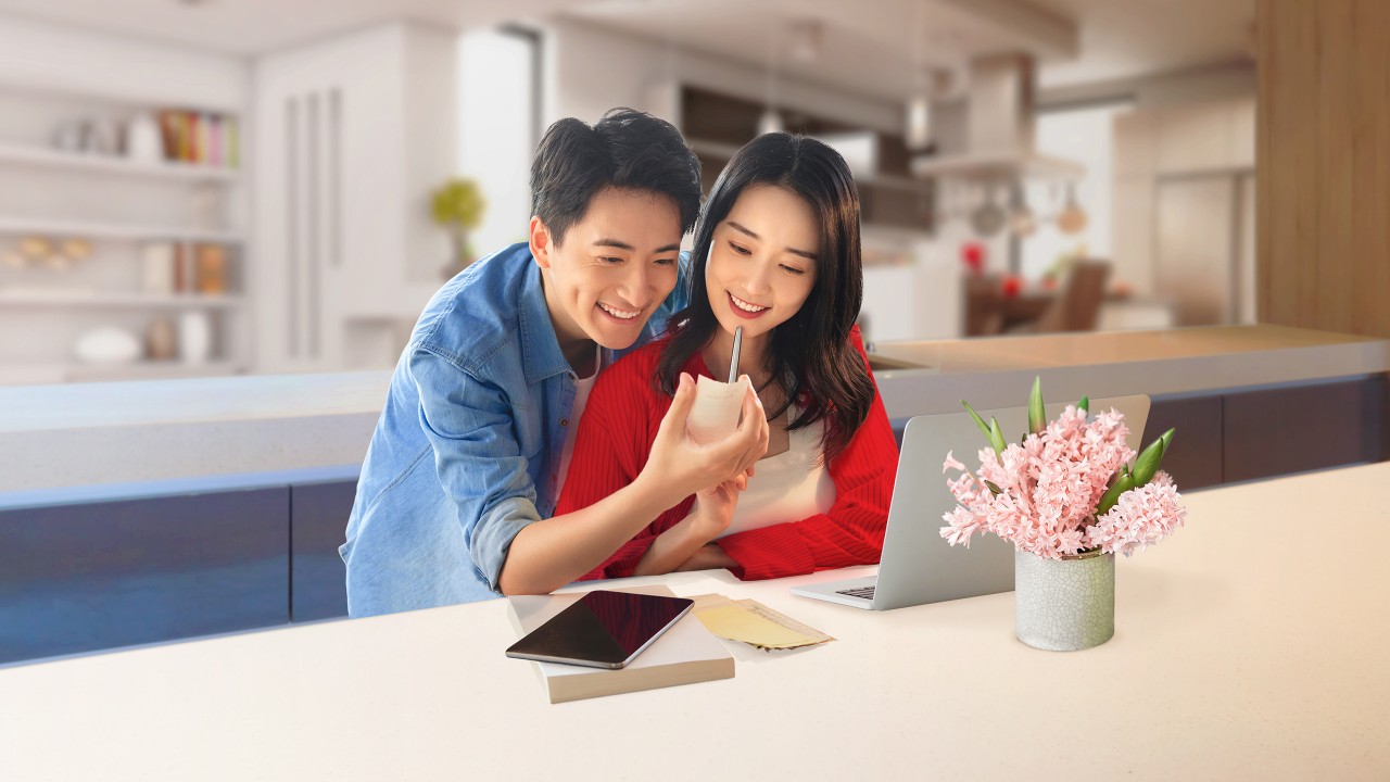 Một cặp đôi trẻ đang kiểm tra hóa đơn phía trước máy tính xách tay; hình ảnh được sử dụng cho trang những câu hỏi thường gặp về hóa đơn thanh toán của HSBC Việt Nam.