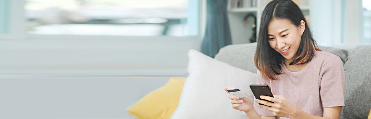 A young woman holding a mobile phone and a card; image used for HSBC Vietnam 3D Secure OTP page