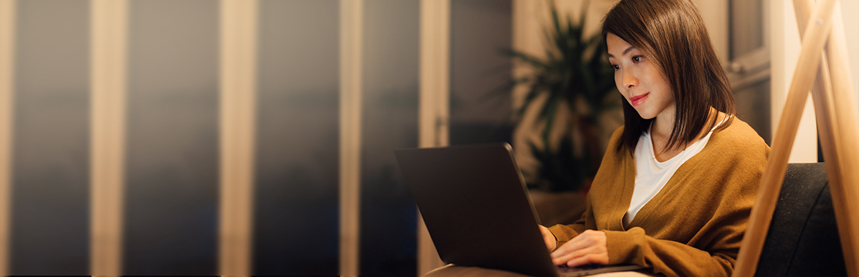 a woman using laptop in home ; image used for HSBC Vietnam Online Banking page