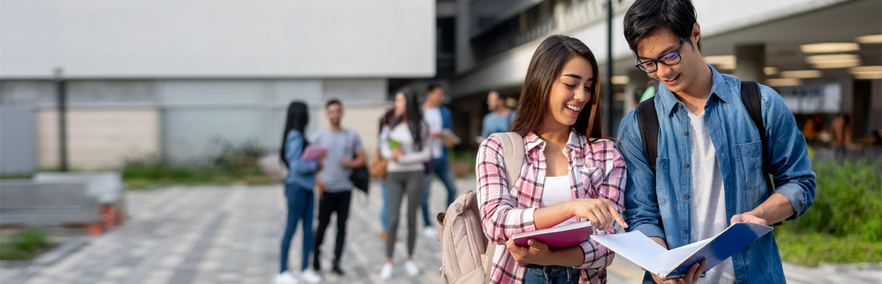 A woman and a man are looking at the notebook together at school; image used for HSBC Vietnam How to plan for study abroad article page.